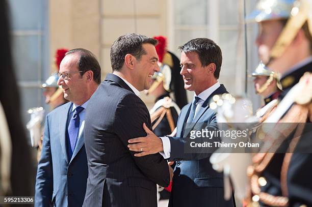 French Prime Minister Manuel Valls and French President Francois Hollande, welcome Greek Prime Minister Alexis Tsipras during a meeting with European...
