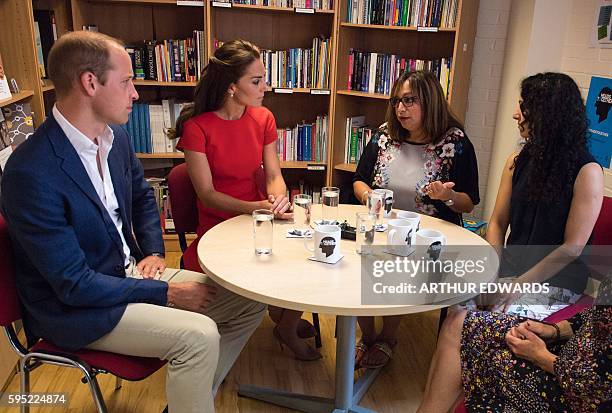 Britain's Catherine, Duchess of Cambridge and Prince William, Duke of Cambridge talk with members of staff and volunteers during a visit to a mental...