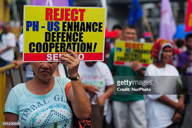 Philippines - Protesters display placards condemning the Enhanced Defense Cooperation Agreement near one of the gates of the presidential palace in...