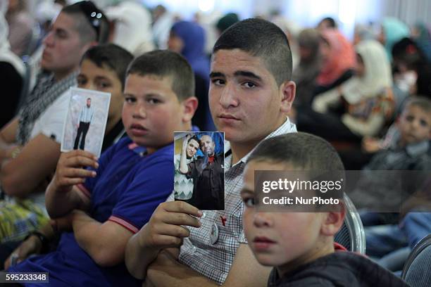 Ramallah, West Bank, Palestinian Territories, April 26, 2014: Palestinian boy hold his father photo how prisoner in Isreal prison during mass rally...
