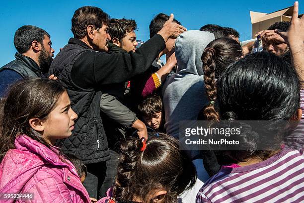 Migrants who queue for food at a makeshift camp at the Greek-Macedonian border, near the Greek village of Idomeni on March 15 where thousands of...