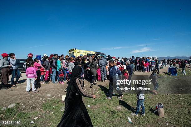 Migrants who queue for food at a makeshift camp at the Greek-Macedonian border, near the Greek village of Idomeni on March 15 where thousands of...