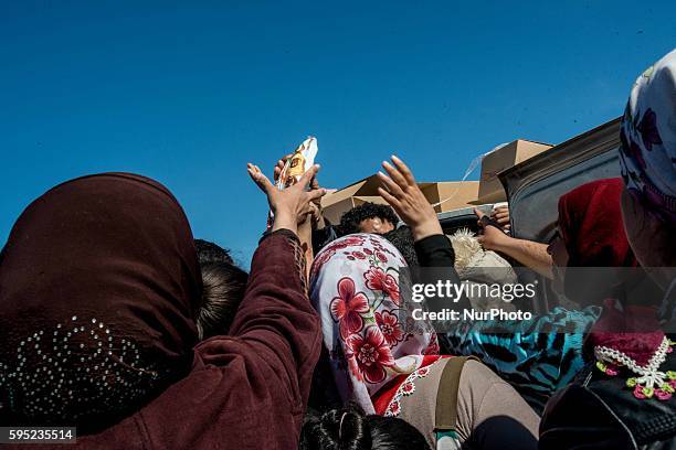 Migrants who queue for food at a makeshift camp at the Greek-Macedonian border, near the Greek village of Idomeni on March 15 where thousands of...