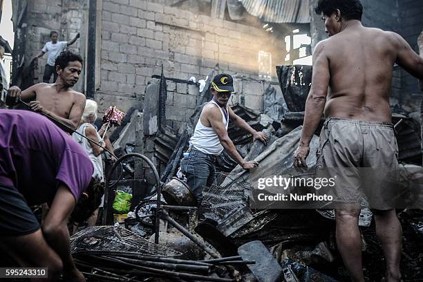 Residents sift through rubble of burned houses in suburban Quezon city, northeast of Manila, Philippines, April 6, 2014. Around 50 houses were razed...