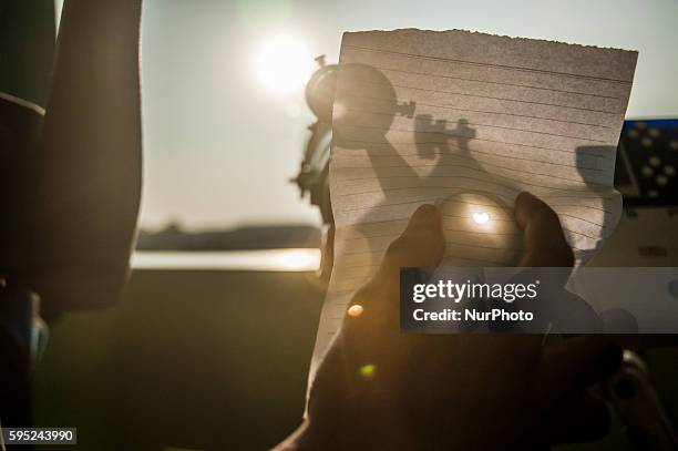 Men showed a Total Solar Eclipse the reflection of light through the paper taken in Islamic Religious High School University, Pekalongan, Central...