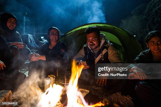 Family sits around a bonfire among other migrants and refugees, at the makeshift camp of the Greek-Macedonian border, near the village of Idomeni, on...