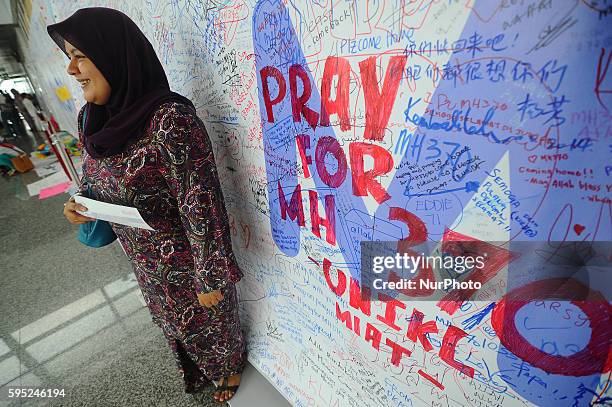 Malaysian Muslim women poses in front of message board and well wishes to people involved with the missing Malaysia Airlines jetliner MH370, Sepang,...