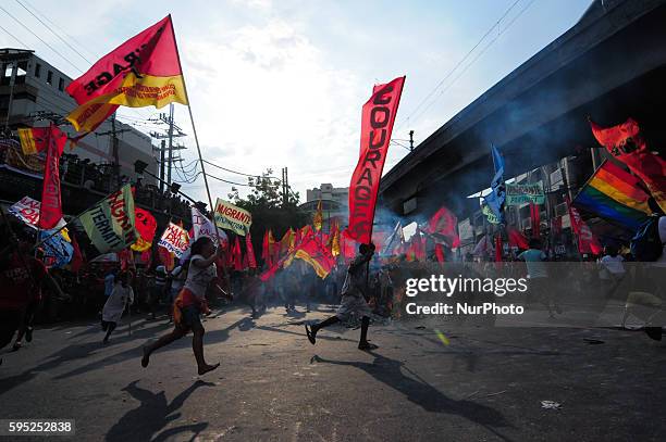 Philippines - Protesters carrying their flags run around the effigy of Philippine President Benigno Aquino III engulfed in flames as thousands of...