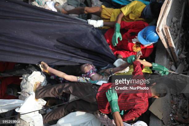 In this photograph taken on April 25 Civilians rescue an injured garment worker during a rescue operation after the eight-storey building Rana Plaza...