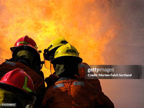 firefighters and a big fire - extinguishing stockfoto's en -beelden