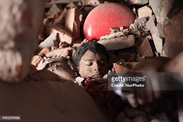 In this photograph taken on April 25 The body of a female garment worker is trapped under the debris of the collapsed building at Savar, Bangladesh....