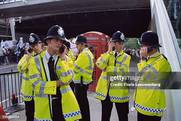 British Police Officer Listening to Walkie-Talkies