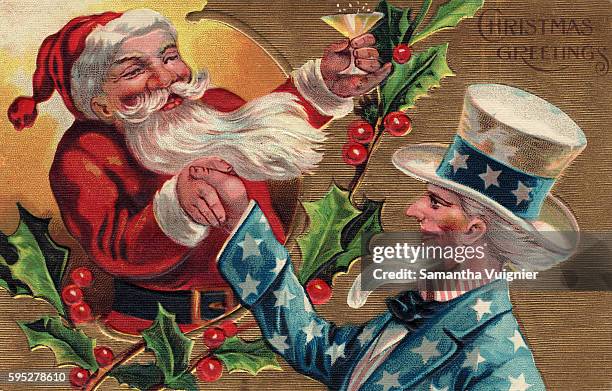 Santa Claus raises a glass of champagne to Uncle Sam while they shake hands over a branch of holly on a Christmas postcard. Circa 1909.