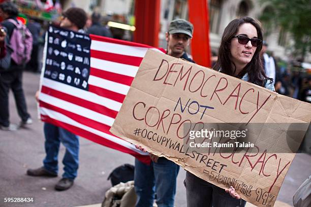 Protestors hold up signs and American flag in Zuccotti Park in Lower Manhattan where they demonstrate against the economic system on Monday,...