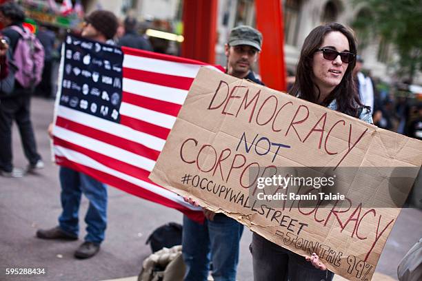 Protestors hold up signs and American flag in Zuccotti Park in Lower Manhattan where they demonstrate against the economic system on Monday,...