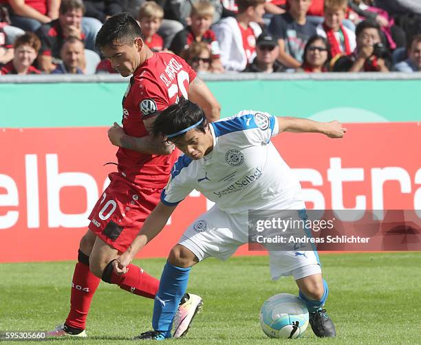 Kazuaki Nishinaka of SC Hauenstein challenges Charles Aranguiz of Bayer Leverkusen during the DFB Cup match between SC Hauenstein and Bayer 04...