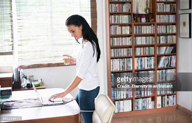 young woman at home,working on her laptop. - 長袖 ストックフォトと画像