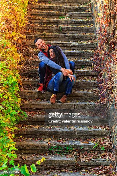 young couple sitting on stairs and having fun - man fallen up the stairs stock pictures, royalty-free photos & images