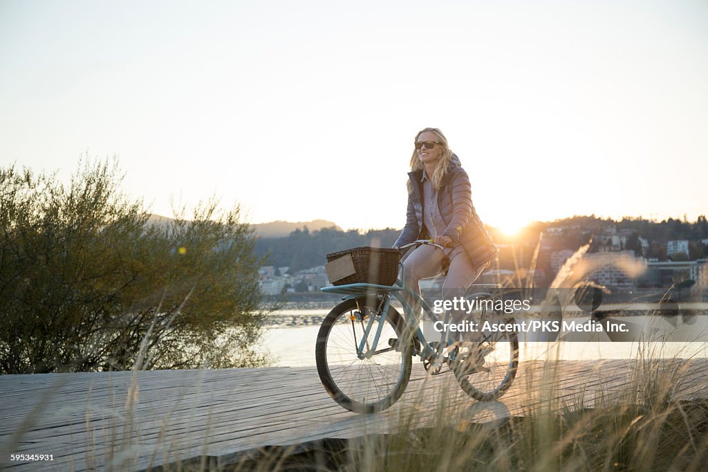 Woman bikes along boardwalk at lakseshore
