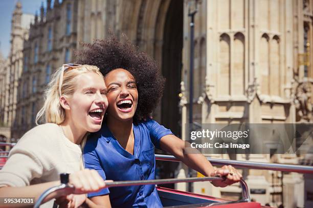 enthusiastic friends laughing on double-decker bus in london - open top bus stock pictures, royalty-free photos & images