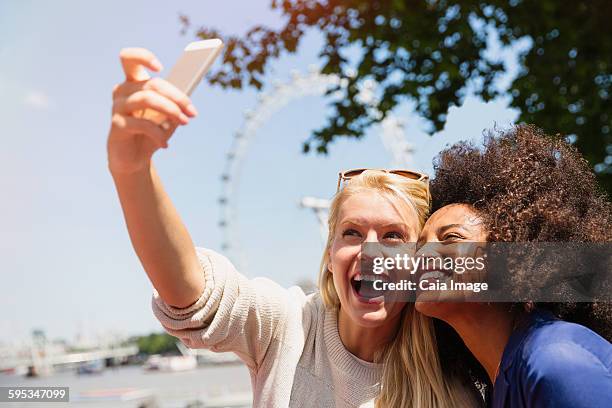 friends taking selfie with london eye in background, london, united kingdom - london eye stock pictures, royalty-free photos & images