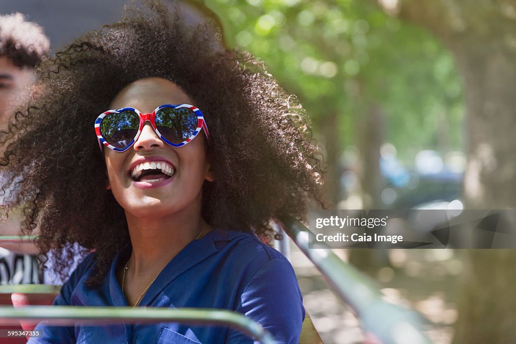 Enthusiastic woman with afro wearing heart-shape glasses