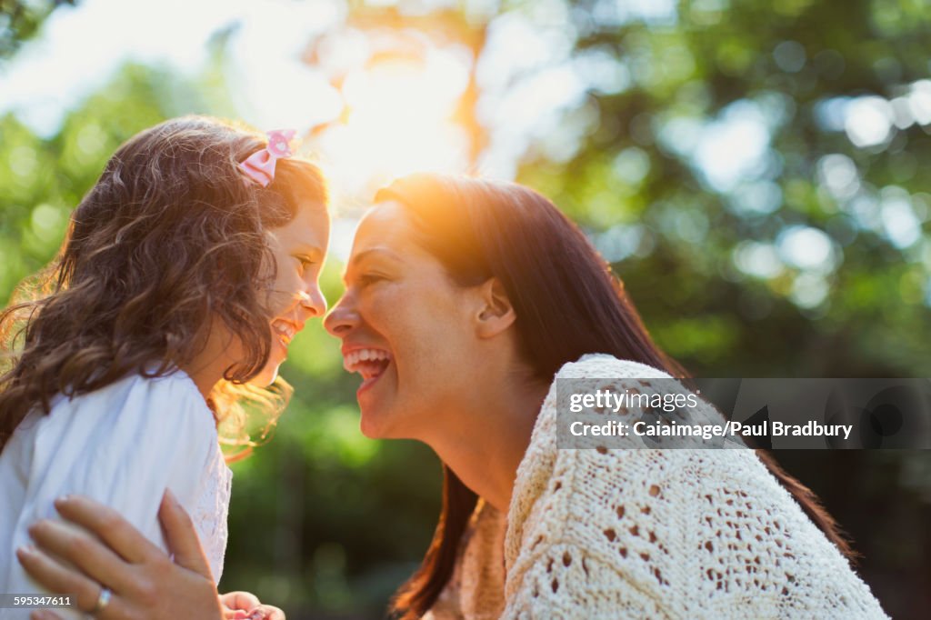 Enthusiastic mother and daughter smiling face to face