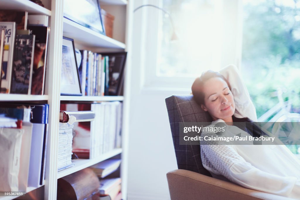 Serene woman napping in armchair