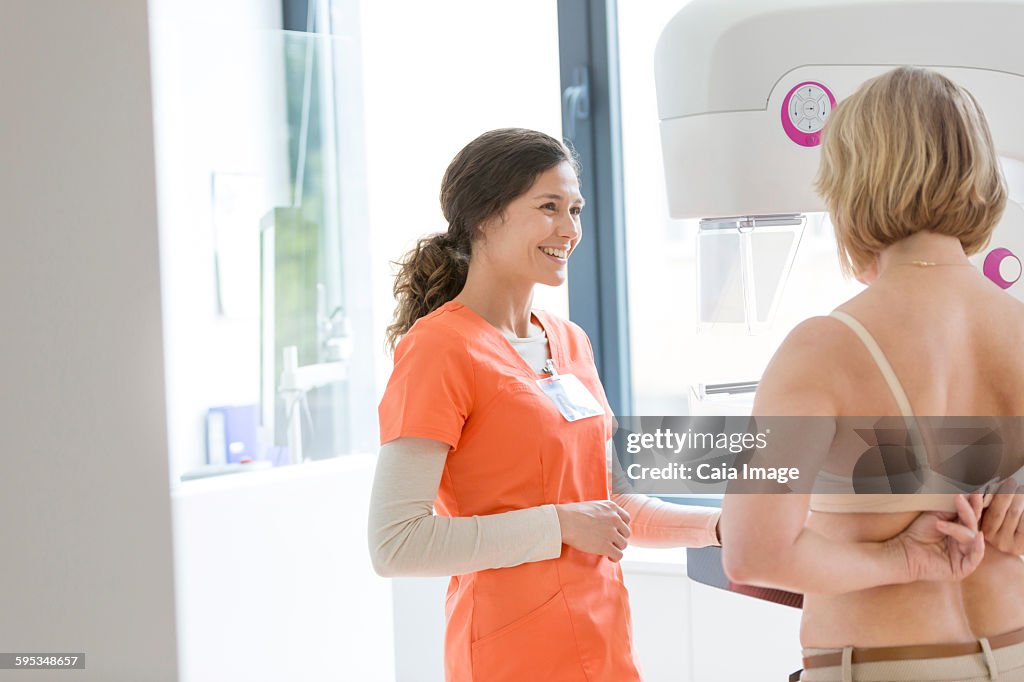 Nurse helping patient prepare for mammogram
