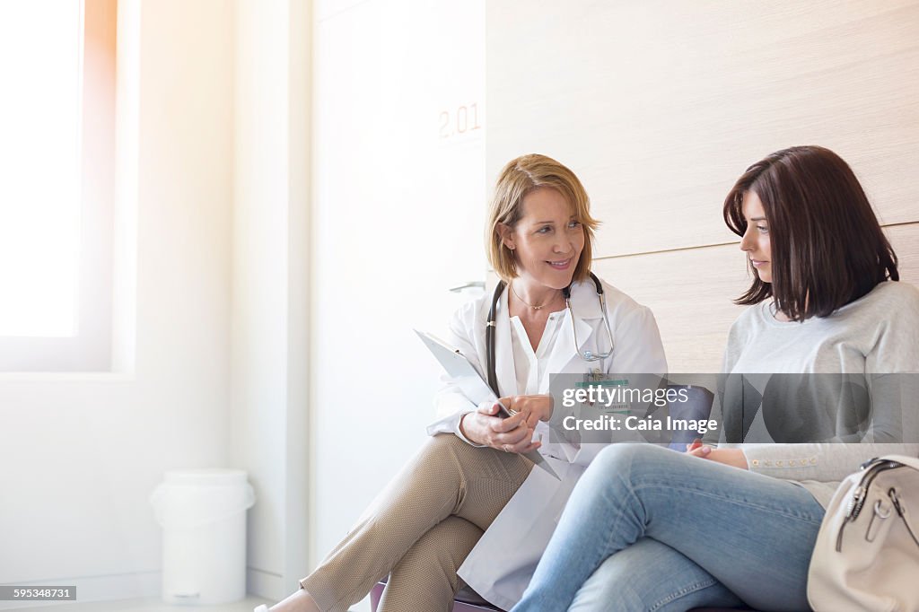 Doctor and patient reviewing medical record in clinic lobby