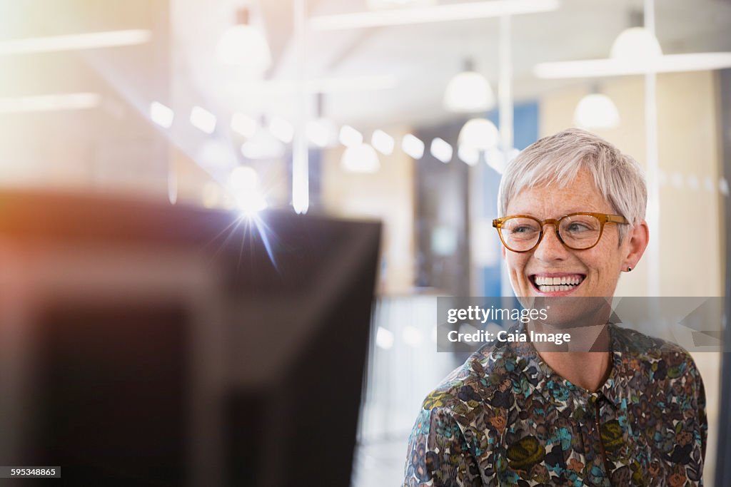 Enthusiastic senior businesswoman looking away in office