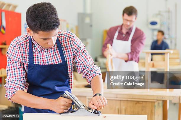 carpenter using plane tool in workshop - woodwork class stock pictures, royalty-free photos & images