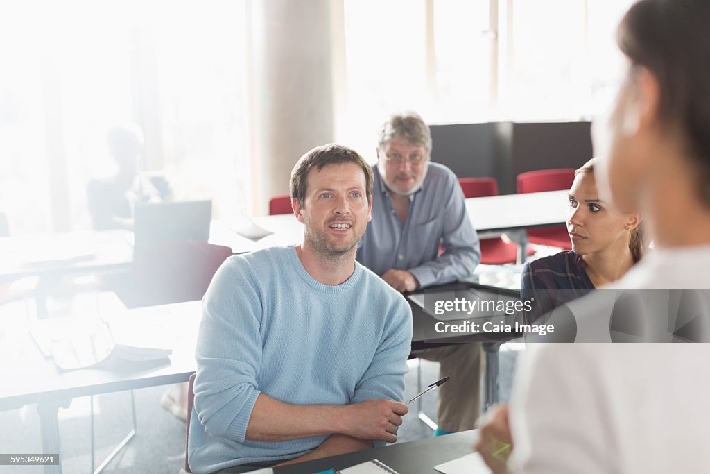 Professor and students talking in adult education classroom