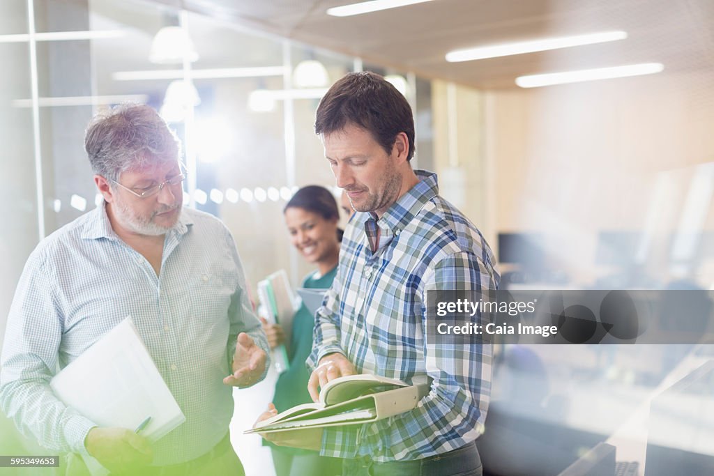 Men discussing book in adult education classroom