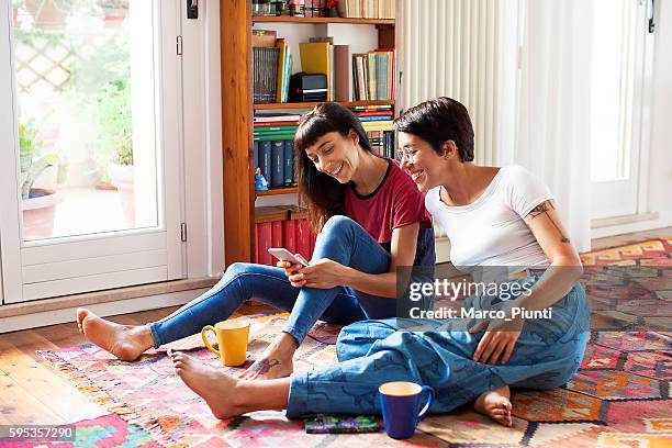 two young women relaxing at home enjoying free time - cool couple in apartment stock pictures, royalty-free photos & images