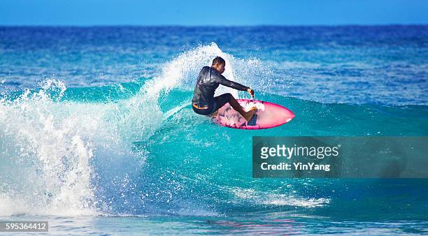 junger mann surfer surfen auf den strand von kauai, hawaii  - big wave surfing stock-fotos und bilder