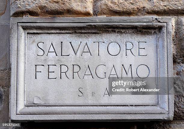 Chiseled stone sign marks the entrance to the Salvatore Ferragamo store and museum on Via Tornabuoni in Florence, Italy. The Italian show designer,...