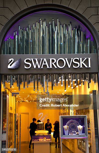 Sales staff members talk inside a Swarovski jewelry and fashion accessories store in Florence, Italy. Founded in 1895 in Austria, Swarovski designs...