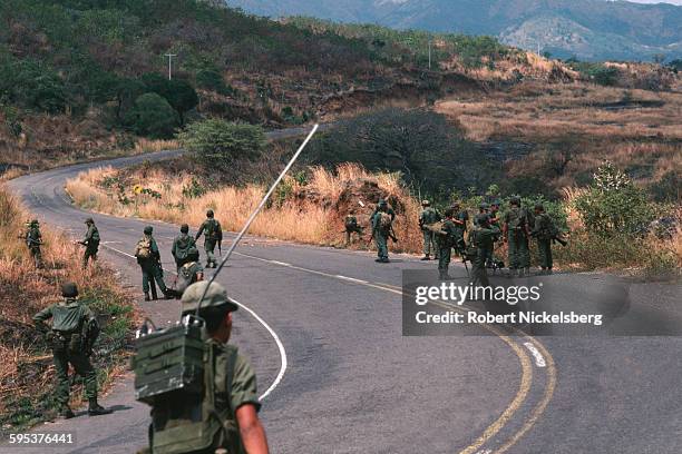 Salvadoran Army soldiers as they patrol a paved road, outskirts of Suchitoto, El Salvador, February 1983. They were near territory controlled by...