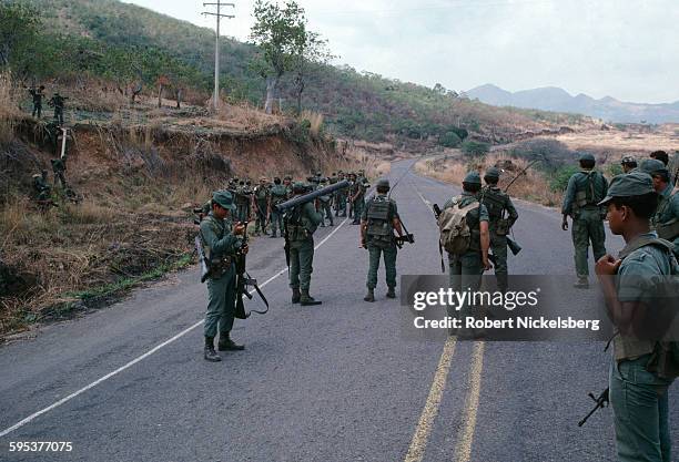 Salvadoran Army soldiers as they patrol a paved road, outskirts of Suchitoto, El Salvador, February 1983. They were near territory controlled by...