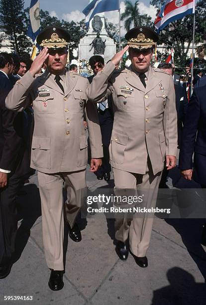 Salvadoran Deputy Minister of Defense Rafael Flores Lima and Minister of Defense General Carlos Eugenio Vides Casanova salute during a military...