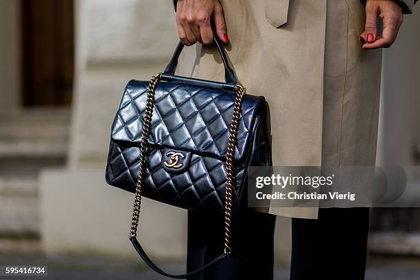 August 25: Golestaneh Mayer-Uellner wearing an oversized beige Celine trench coat, black wide leg pants from 3.1 Phillip Lim, a black Chanel handle...