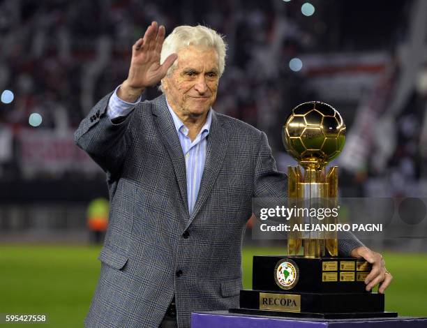 Argentina's River Plate former goalkeeper Amadeo Carrizo waves as he poses next the trophy before the Recopa Sudamericana 2016 second leg final...