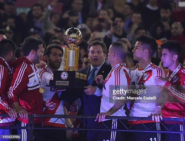 Alejandro Dominguez President of Conmebol gives the trophy to Leonardo Ponzio and Andres D'Alessandro of River Plate after a second leg match between...