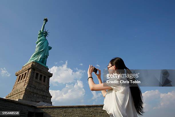 woman taking picture of statue of liberty, new york city, usa - mobile sculpture fotografías e imágenes de stock