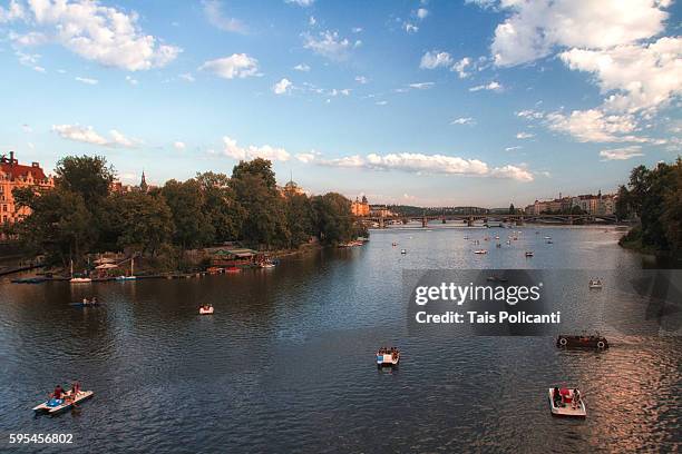 little boats in the vltava river in prague at sunset, czech republic, europe - tancici dum stock pictures, royalty-free photos & images
