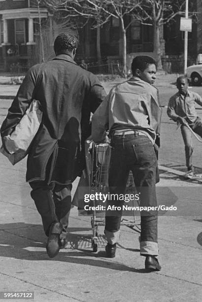 During a riot in Baltimore, Maryland, two African-American men use a shopping cart to carry off looted goods, Baltimore, Maryland, 1943.