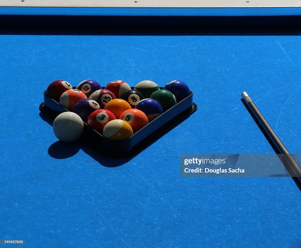 Close-Up Of Pool Balls By Cue On a outdoor blue Billiard Table