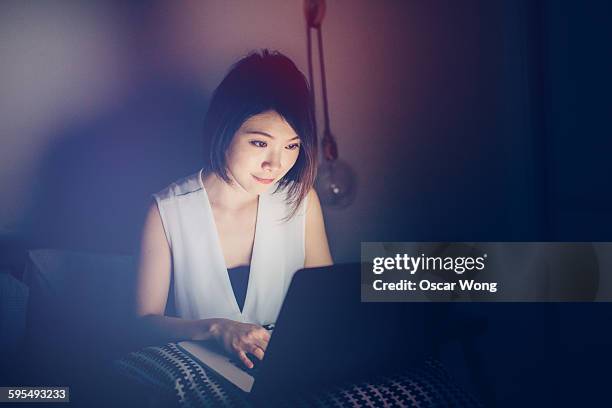 Young woman using laptop on bed