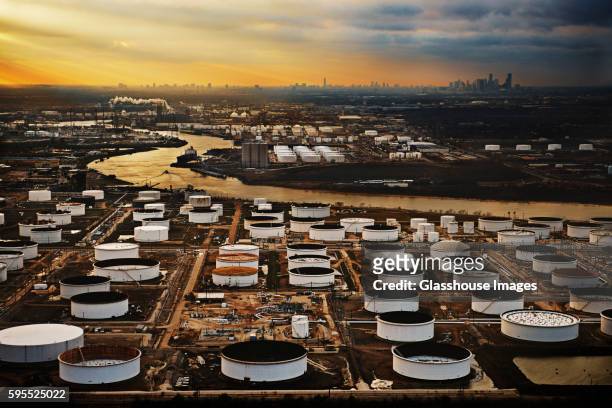 storage tanks at oil refinery with houston texas, usa skyline in background at sunset - houston texas night stock pictures, royalty-free photos & images